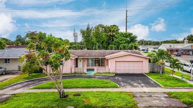 single story home featuring a front lawn and a garage