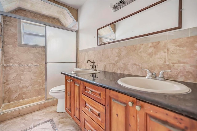 bathroom featuring walk in shower, vanity, toilet, and tile walls