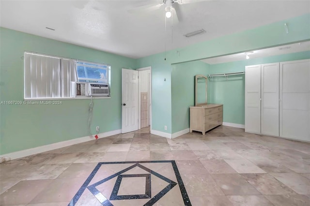 unfurnished bedroom featuring ceiling fan, cooling unit, and a closet