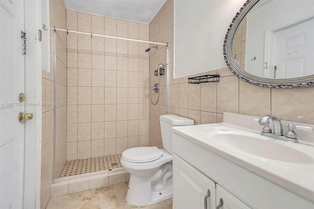 bathroom with toilet, vanity, tile walls, and tiled shower