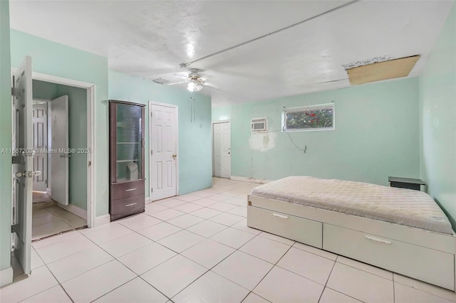 bedroom with ceiling fan, light tile patterned floors, and a wall unit AC