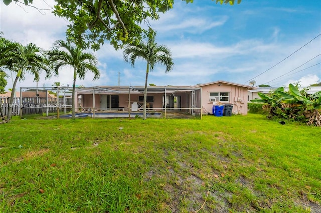 back of house with a lawn and a lanai