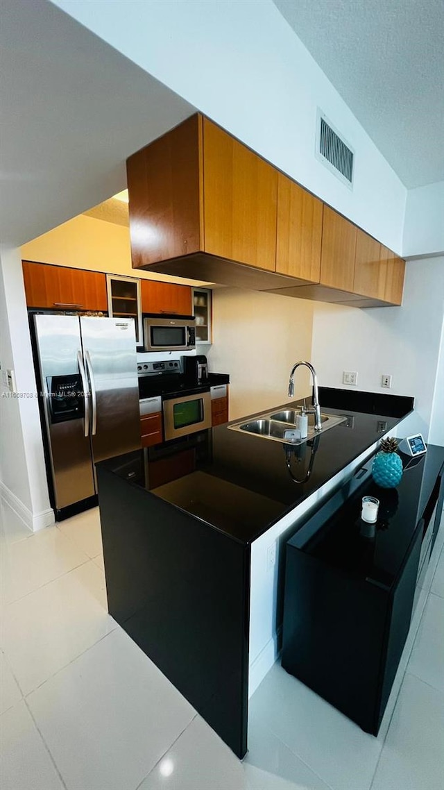 kitchen with stainless steel appliances, light tile patterned floors, and sink