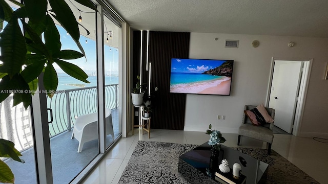 living room with a textured ceiling and light tile patterned flooring