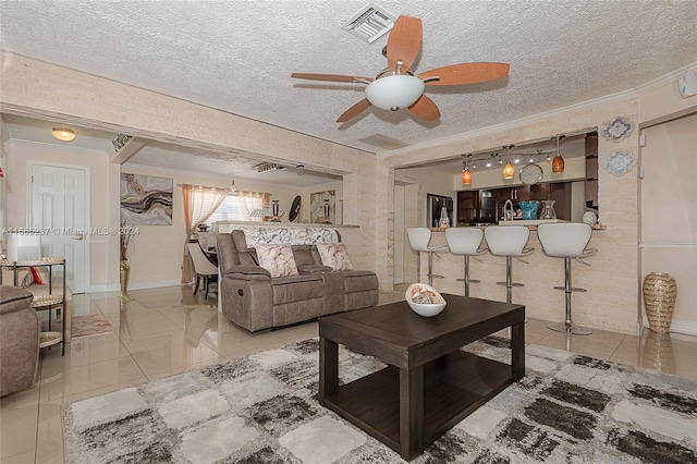 living room with ornamental molding, a textured ceiling, and ceiling fan