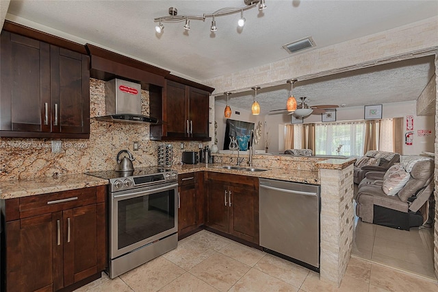 kitchen featuring a textured ceiling, sink, ceiling fan, and stainless steel appliances