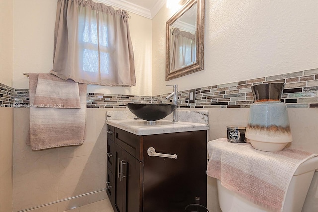 bathroom featuring tile walls, toilet, vanity, and crown molding