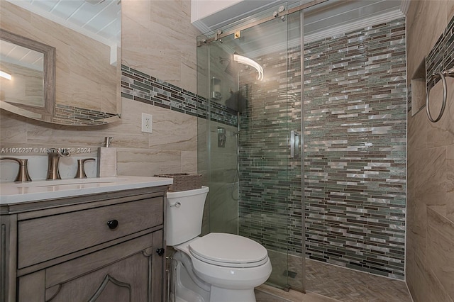 bathroom featuring tile walls, decorative backsplash, vanity, a shower with door, and toilet