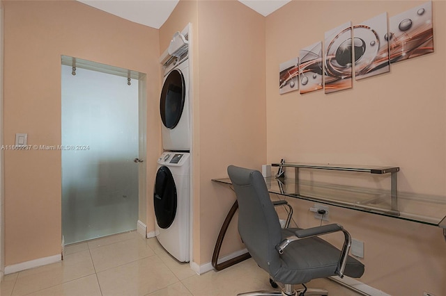 clothes washing area featuring light tile patterned floors and stacked washer and dryer