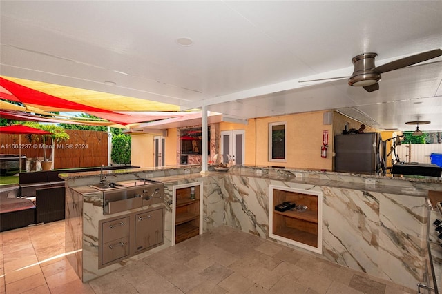 kitchen with black fridge, kitchen peninsula, and ceiling fan