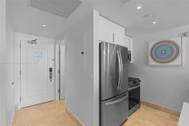 kitchen with stainless steel refrigerator, electric stove, white cabinets, and electric panel