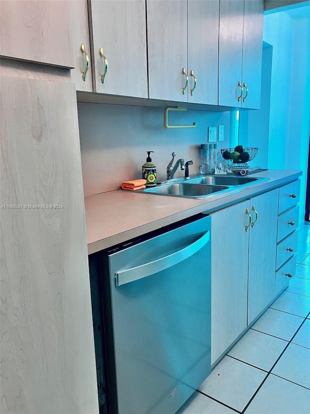 kitchen with sink, light tile patterned floors, and stainless steel dishwasher