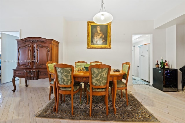 dining room with light hardwood / wood-style floors and beverage cooler