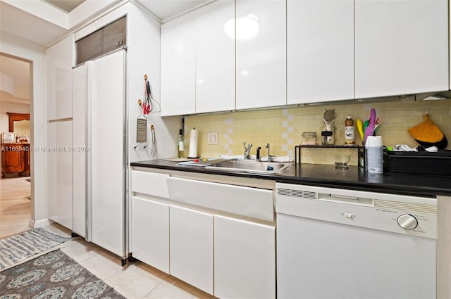 kitchen featuring decorative backsplash, light tile patterned floors, white dishwasher, and white cabinetry