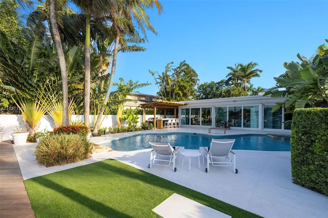 view of swimming pool with a patio and a lawn