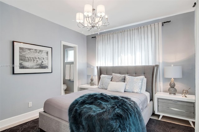 bedroom with ensuite bathroom and a notable chandelier