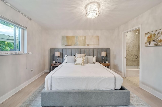 bedroom with ensuite bath and light hardwood / wood-style floors