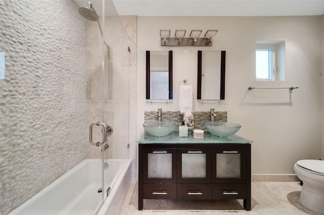 full bathroom with tile patterned flooring, combined bath / shower with glass door, vanity, and toilet