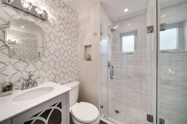 bathroom with backsplash, a shower with shower door, vanity, and toilet