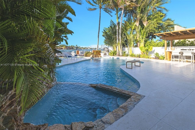 view of swimming pool featuring a jacuzzi and a patio area