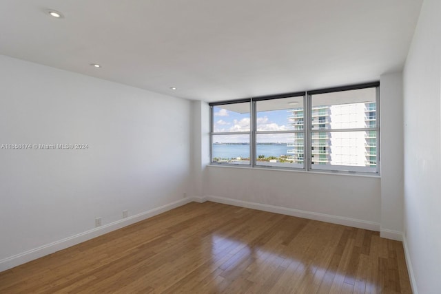 empty room featuring hardwood / wood-style flooring and a water view