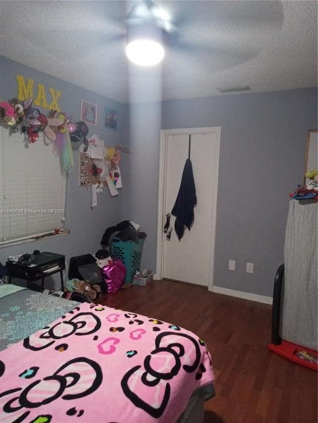 bedroom with dark hardwood / wood-style flooring and a textured ceiling