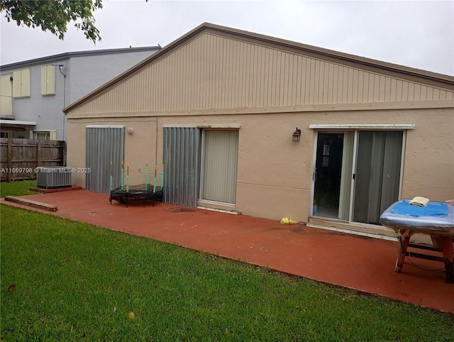 back of property with central AC unit, a yard, and a patio