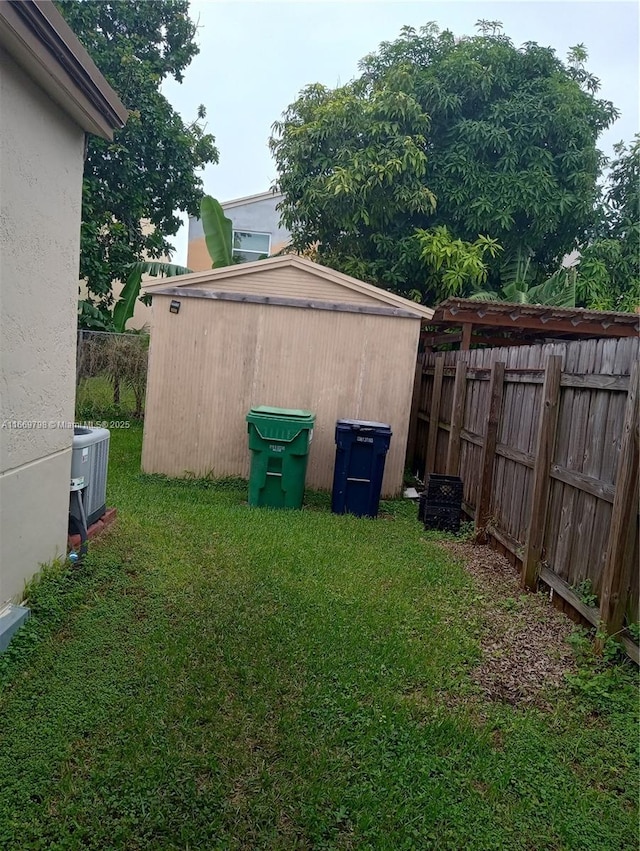 view of yard featuring a storage unit and central AC unit