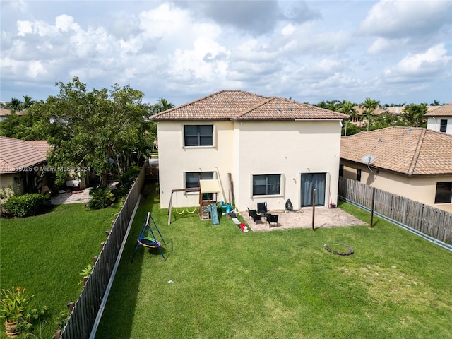 back of property with a patio, a playground, and a lawn