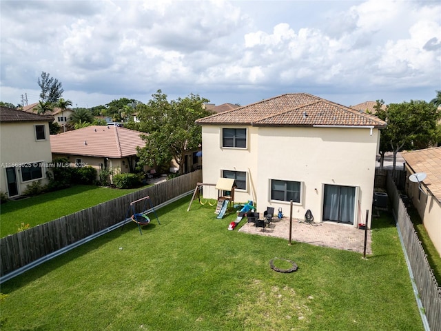 back of property with a yard and a patio area