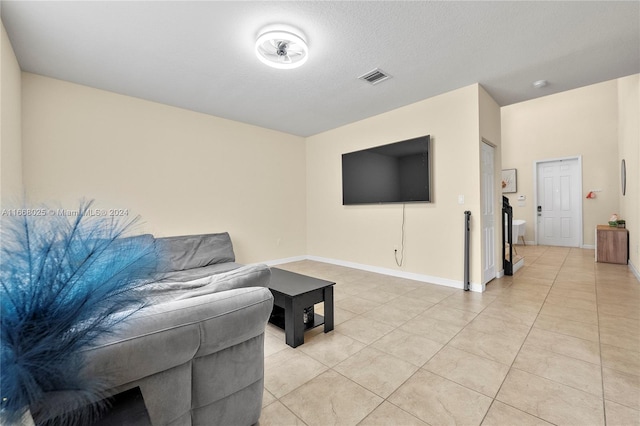 tiled living room featuring a textured ceiling