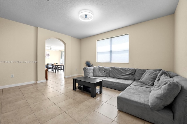 tiled living room featuring a textured ceiling