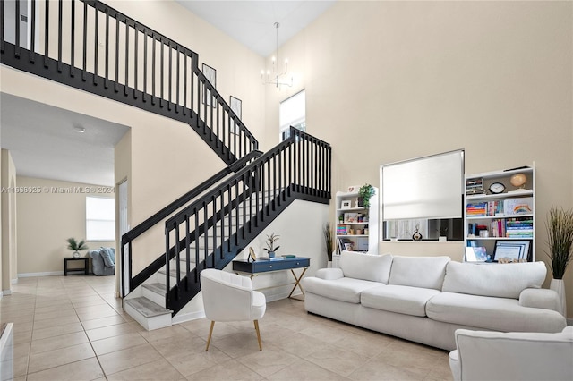 living room featuring a towering ceiling, a notable chandelier, and light tile patterned floors