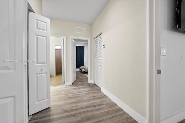 corridor with light hardwood / wood-style floors