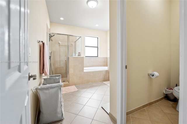 bathroom featuring toilet, shower with separate bathtub, and tile patterned floors