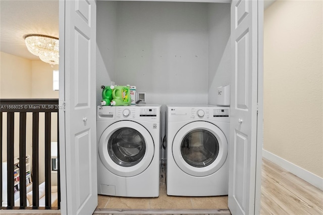 washroom featuring light hardwood / wood-style flooring, a chandelier, and independent washer and dryer