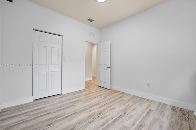 unfurnished bedroom with a closet and light hardwood / wood-style flooring