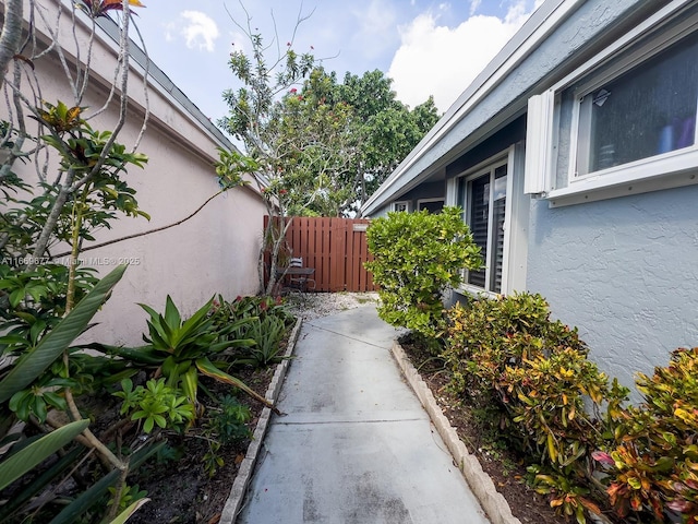 view of property exterior featuring stucco siding and fence