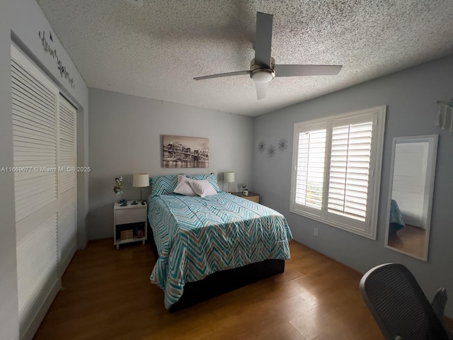 bedroom featuring a closet, wood finished floors, ceiling fan, and a textured ceiling