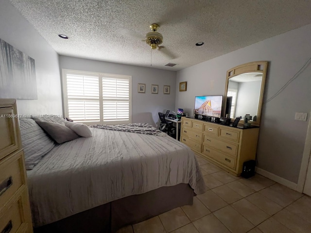 tiled bedroom featuring ceiling fan and a textured ceiling