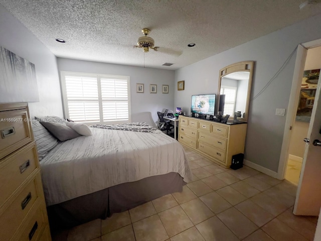 tiled bedroom featuring a textured ceiling and ceiling fan