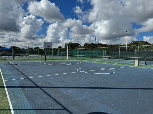 view of sport court featuring a tennis court, fence, and community basketball court