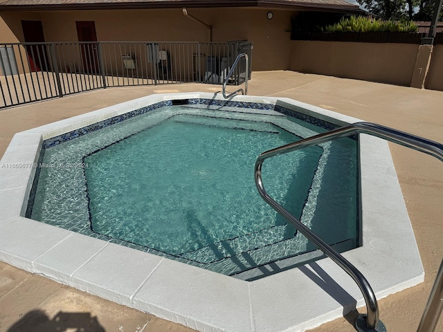 view of pool with a hot tub