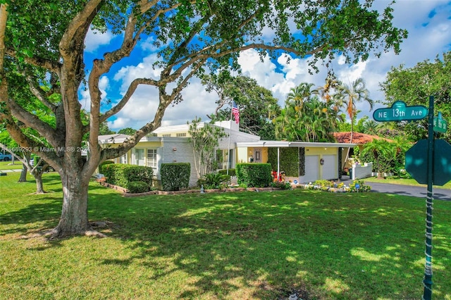 ranch-style home with a garage and a front lawn