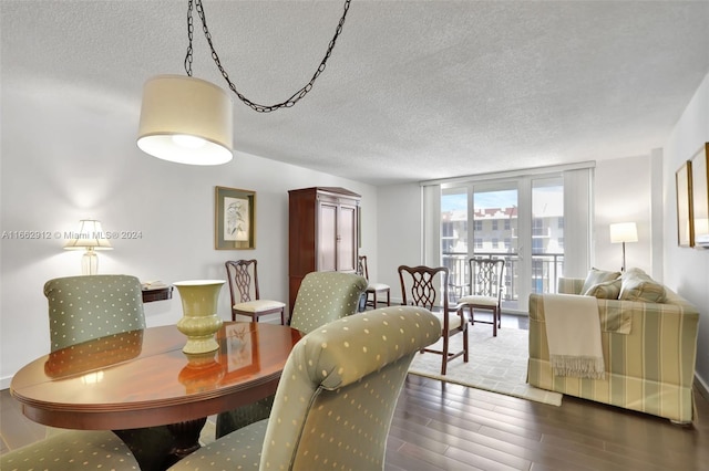 dining space with a textured ceiling and dark hardwood / wood-style flooring