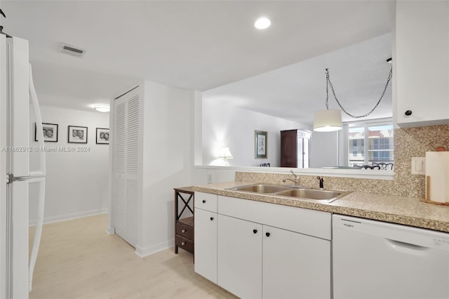 kitchen with sink, white cabinets, hanging light fixtures, backsplash, and white appliances