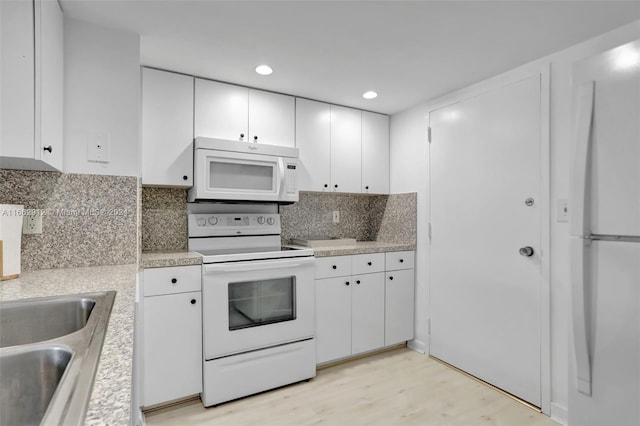 kitchen with white cabinets, sink, white appliances, light hardwood / wood-style flooring, and decorative backsplash