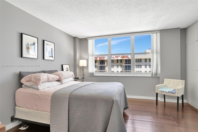 bedroom featuring a textured ceiling and dark wood-type flooring