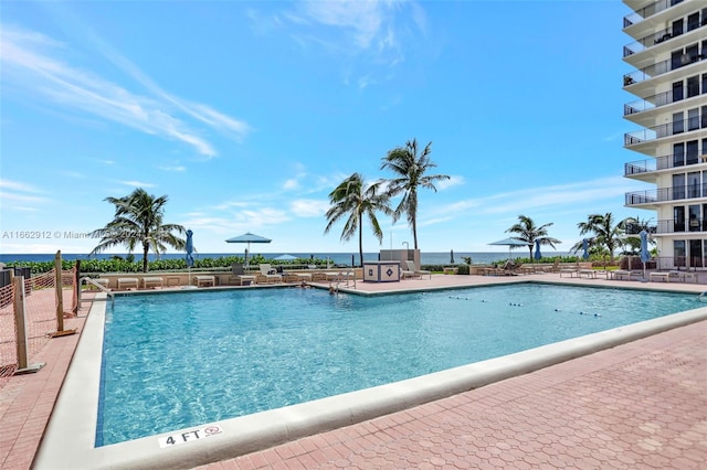 view of swimming pool featuring a water view and a patio area