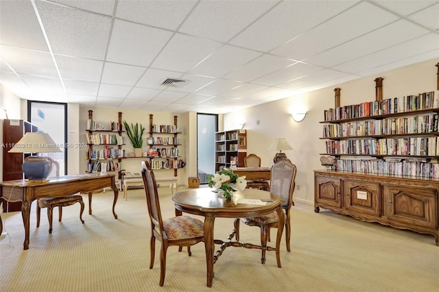 carpeted dining room with a drop ceiling